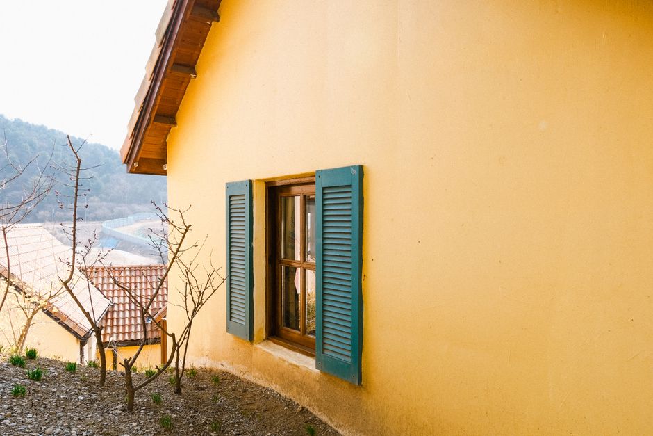 A yellow house with blue shutters and a painted exterior.